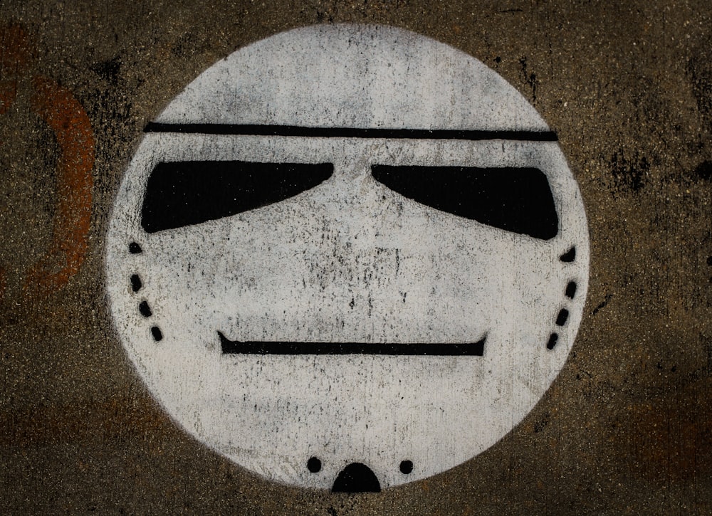 a white face painted on a cement surface