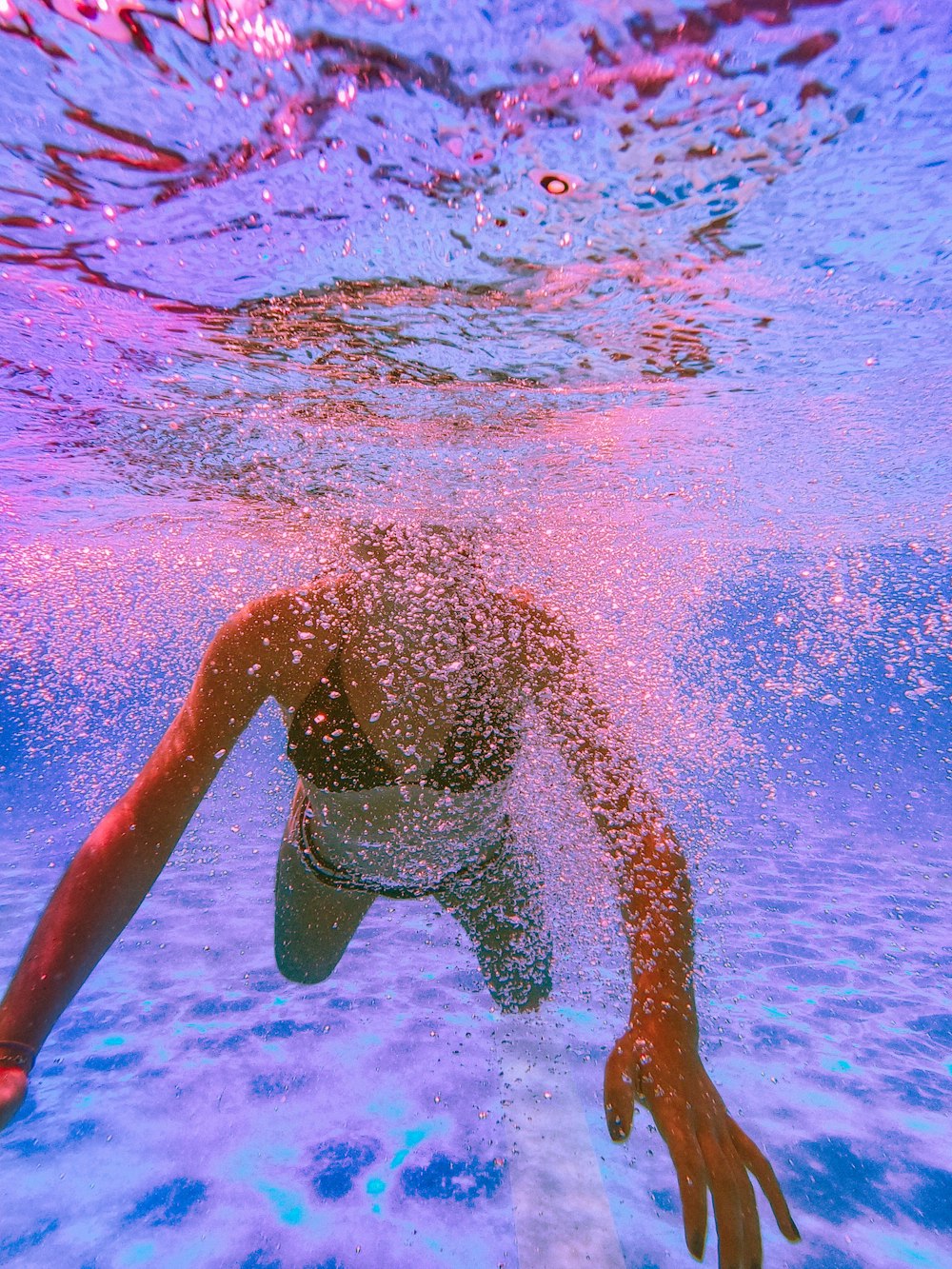a person swimming under water in a pool