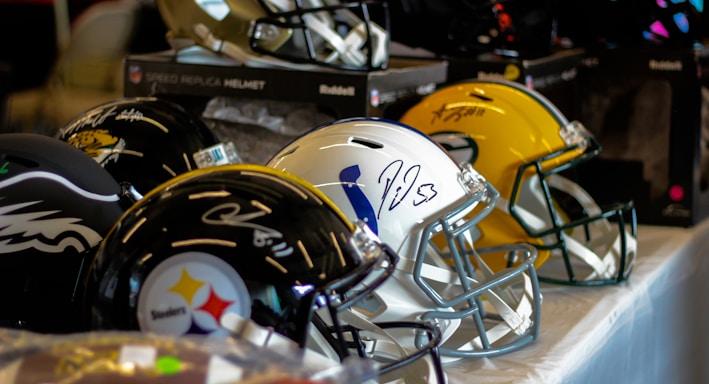 a row of football helmets sitting on top of a table