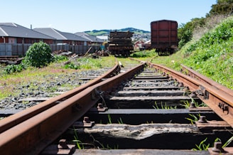 a train track with a bunch of train cars in the background