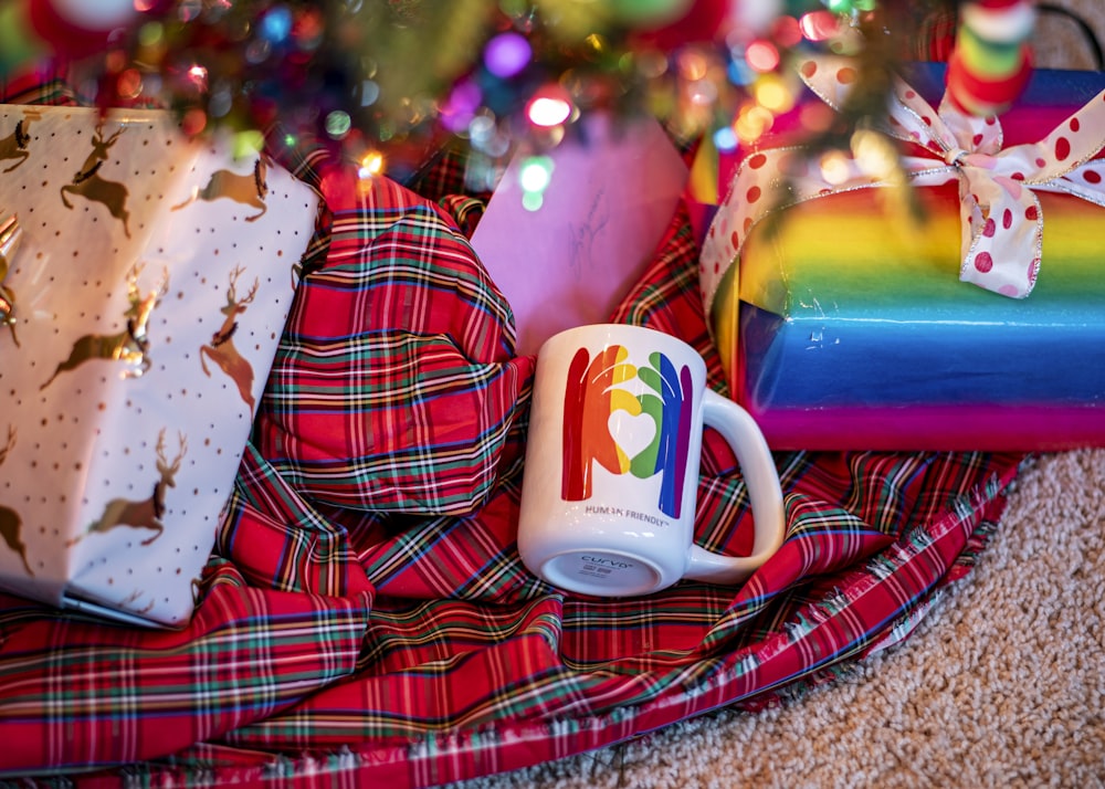 a coffee mug sitting on top of a pile of presents
