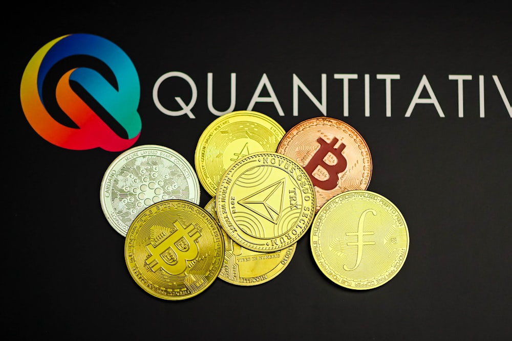 a pile of coins sitting next to a quatitive logo