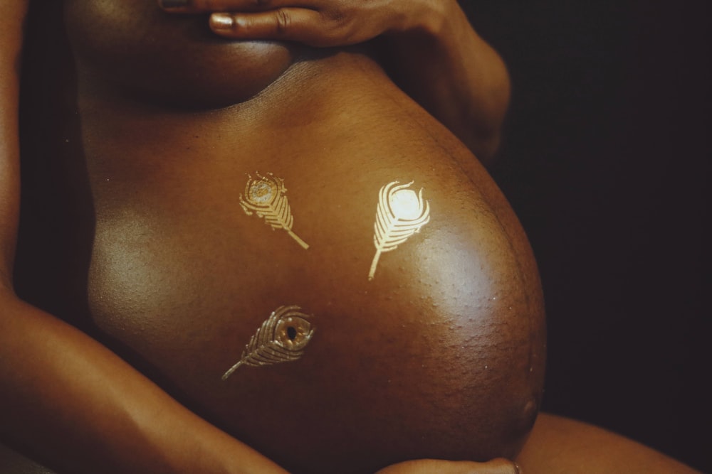 una mujer embarazada con tatuajes en el vientre