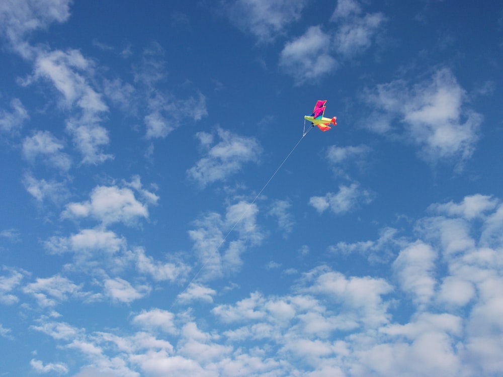 a person flying a kite in a blue sky