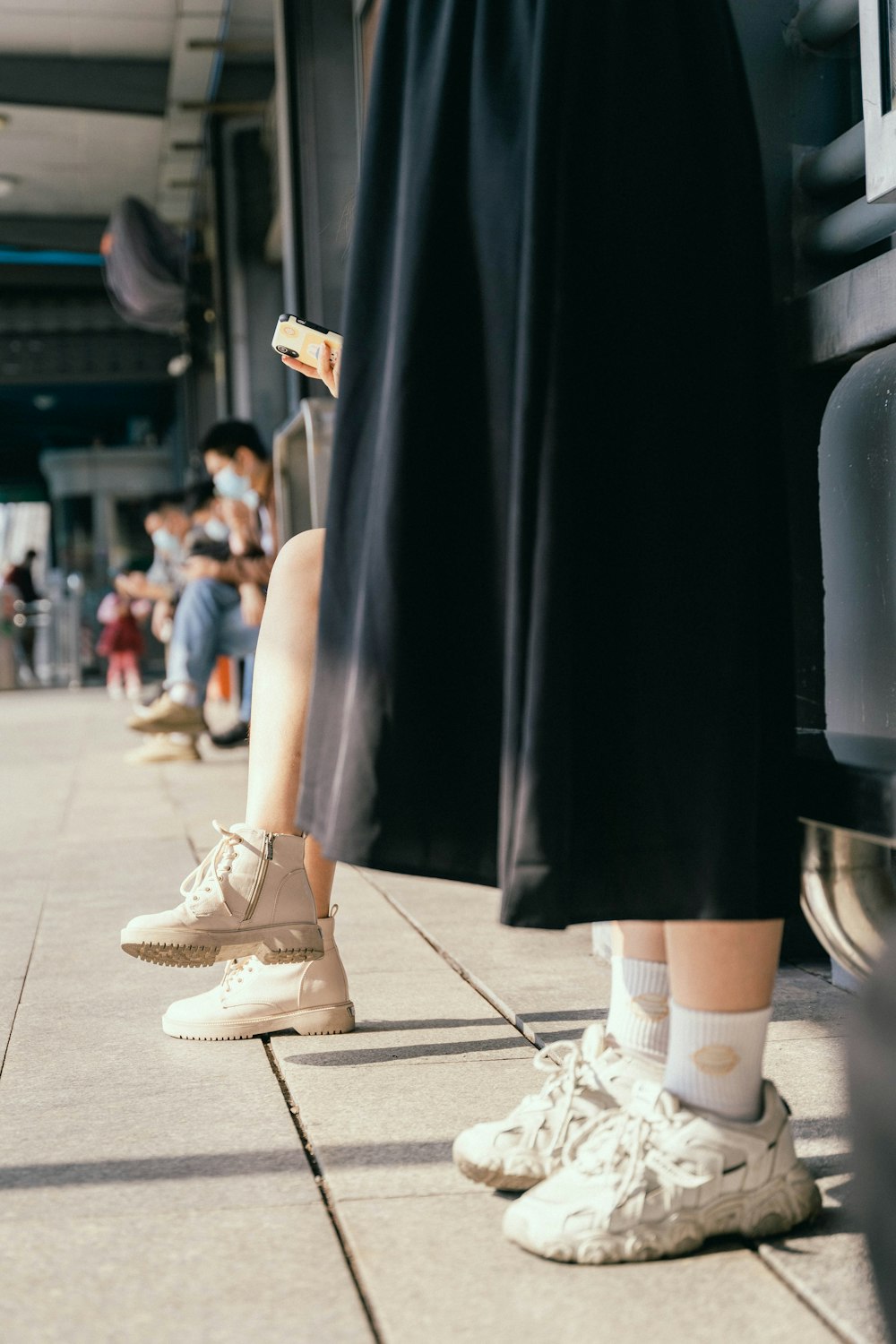 a person standing next to a bus on a sidewalk