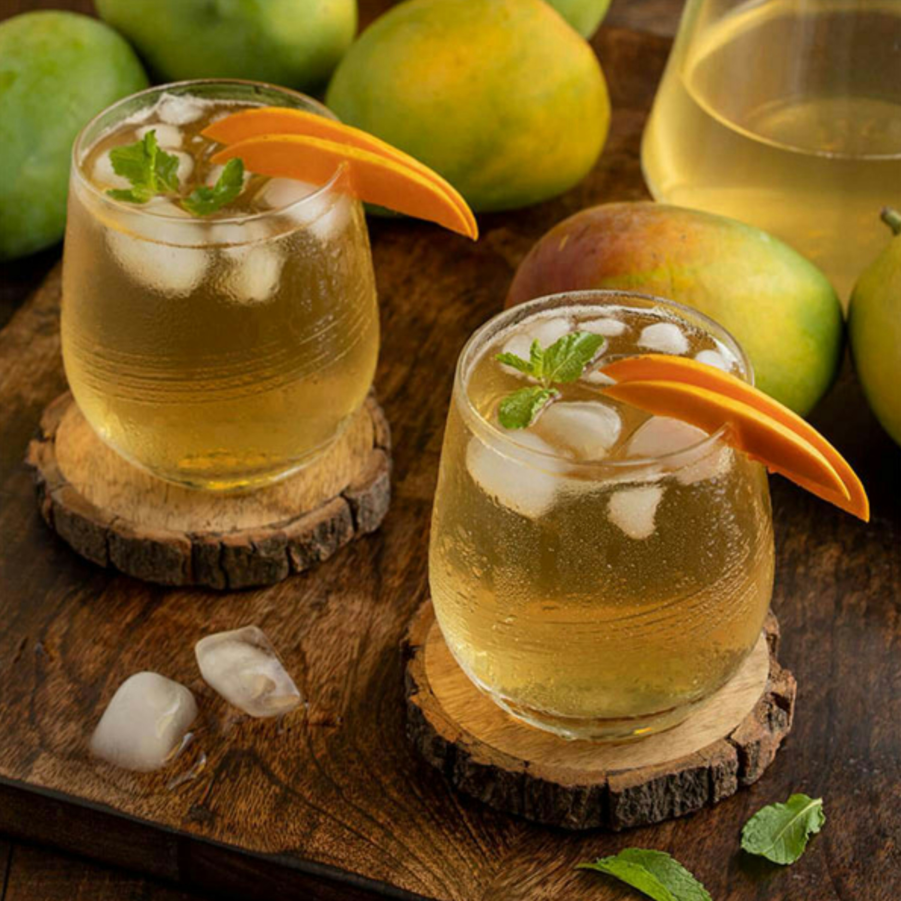 a couple of glasses filled with liquid next to some fruit