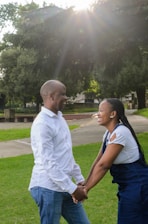 A romantic couple holding hands in a beautiful outdoor setting.