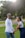 A smiling couple holding hands in a naturally lit, serene outdoor setting.