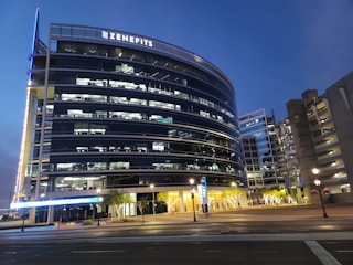 A sleek office building equipped with smart IoT sensors glowing softly at dusk.