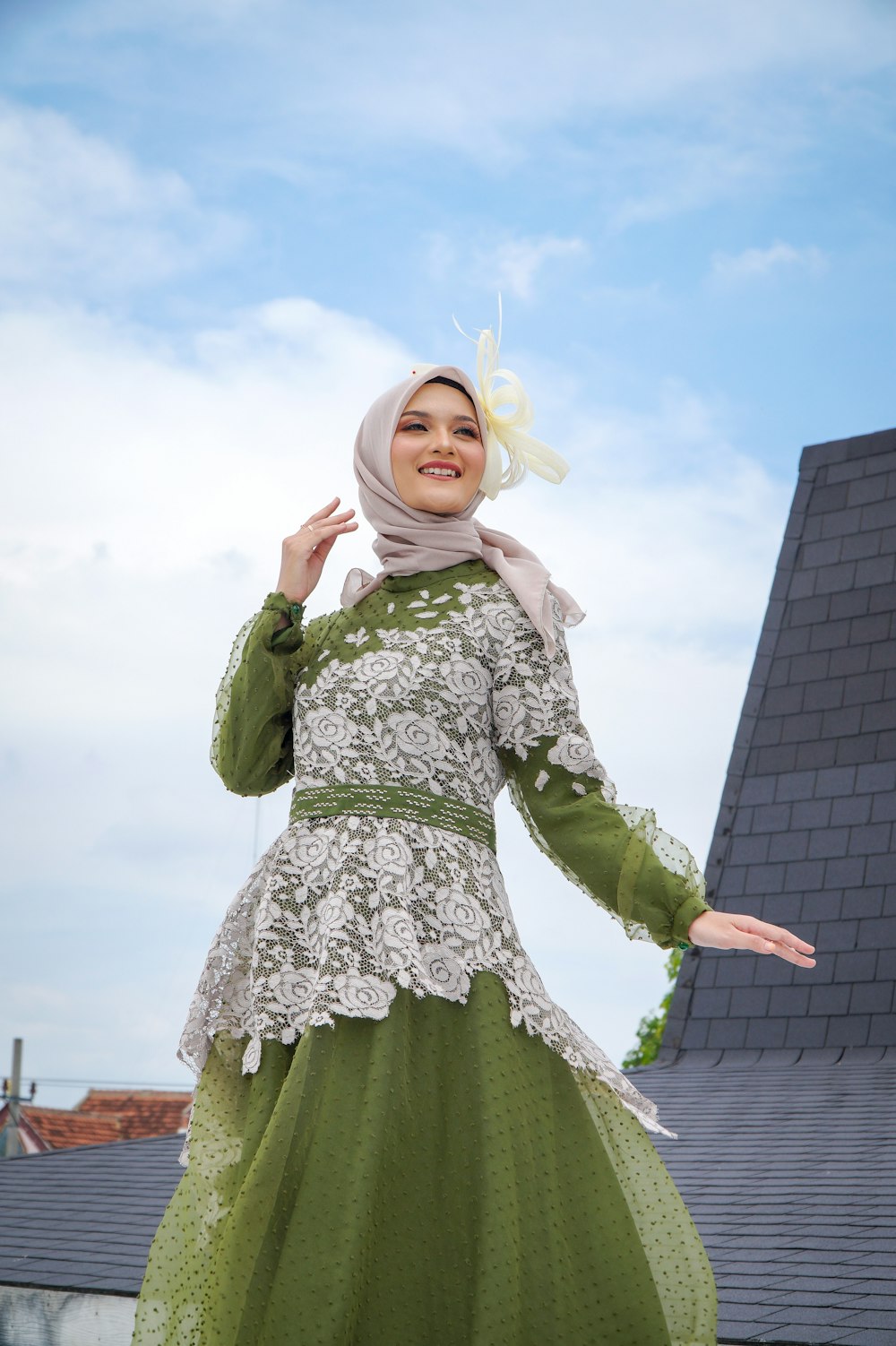 Una mujer con un vestido verde y un hijab
