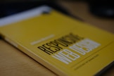 a yellow book sitting on top of a wooden table