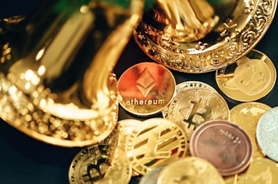 A collection of various cryptocurrency coins are scattered, including prominent ones like Ethereum and Bitcoin, surrounded by decorative golden objects.