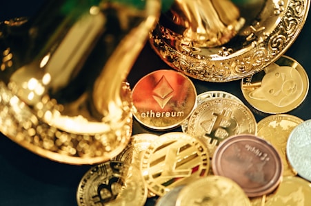 A collection of various cryptocurrency coins are scattered, including prominent ones like Ethereum and Bitcoin, surrounded by decorative golden objects.