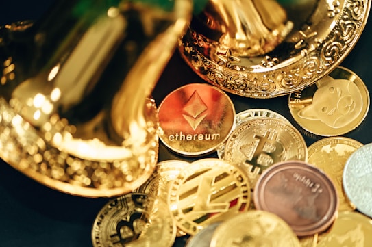 A collection of various cryptocurrency coins are scattered, including prominent ones like Ethereum and Bitcoin, surrounded by decorative golden objects.