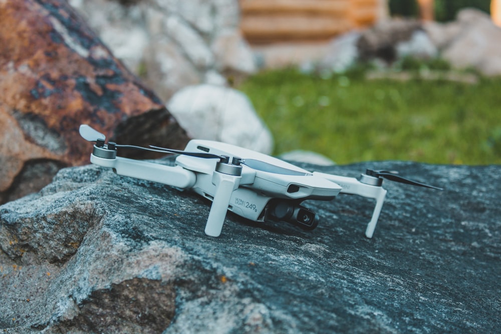 a small white remote control flying over a rock