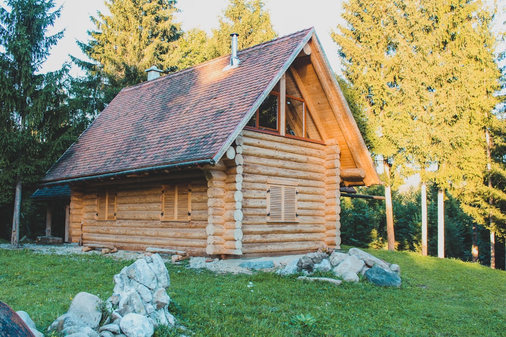 a log cabin sits in the middle of a field