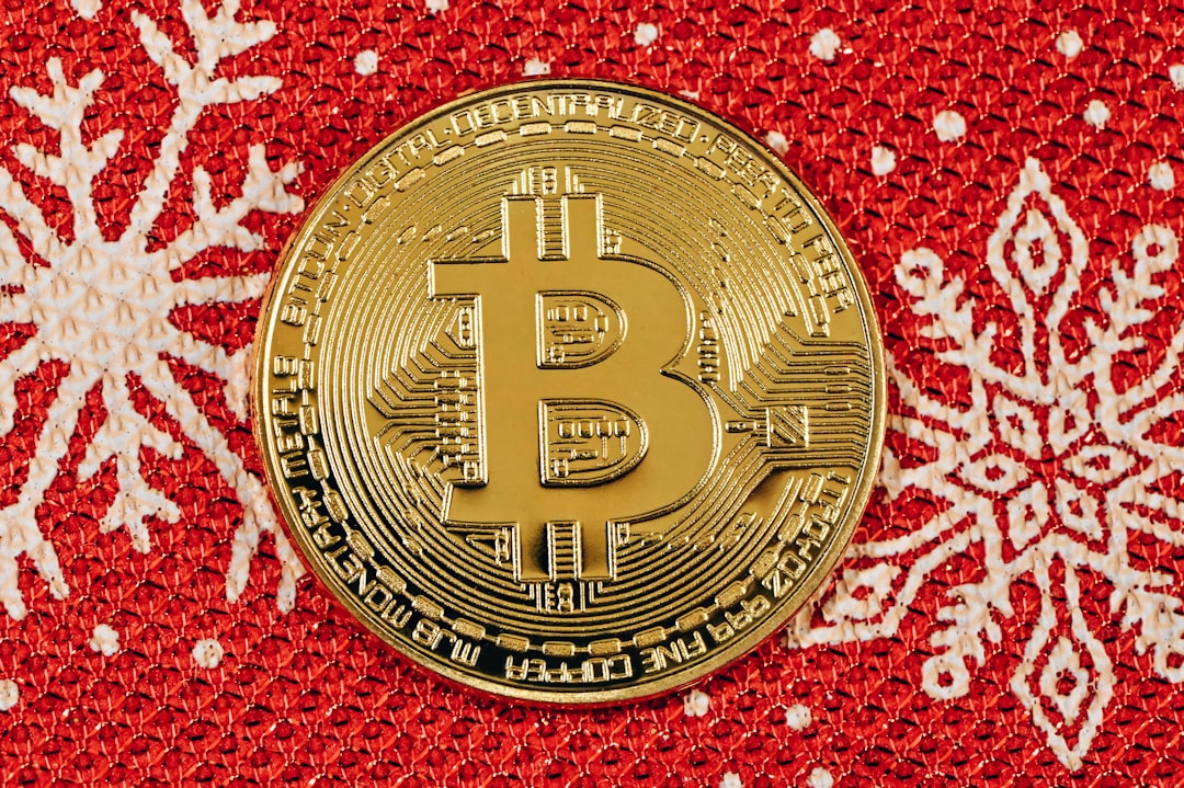 A gold Bitcoin placed on a red Christmas background