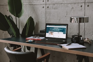 a laptop computer sitting on top of a wooden desk