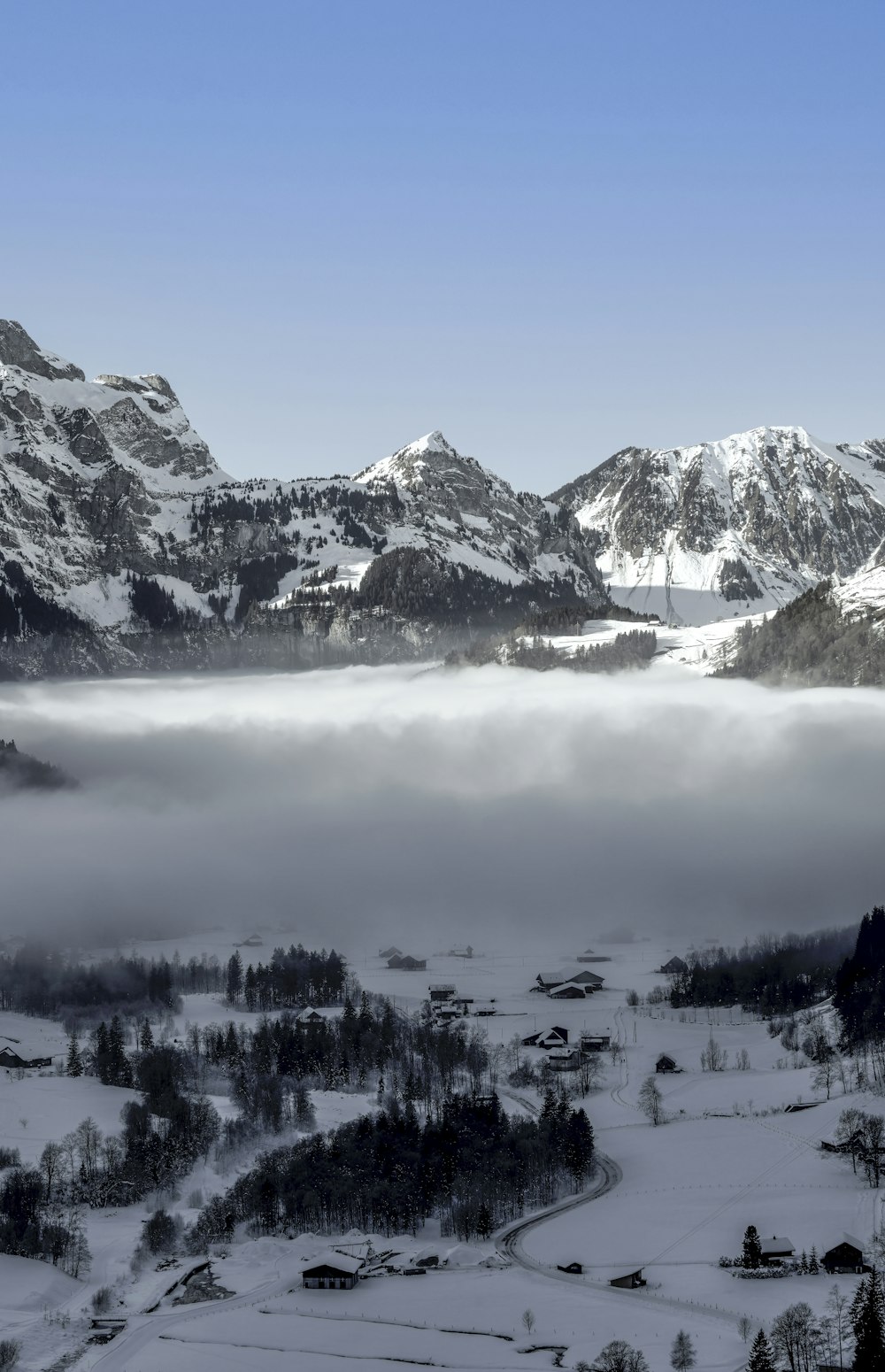 a mountain range covered in snow and clouds