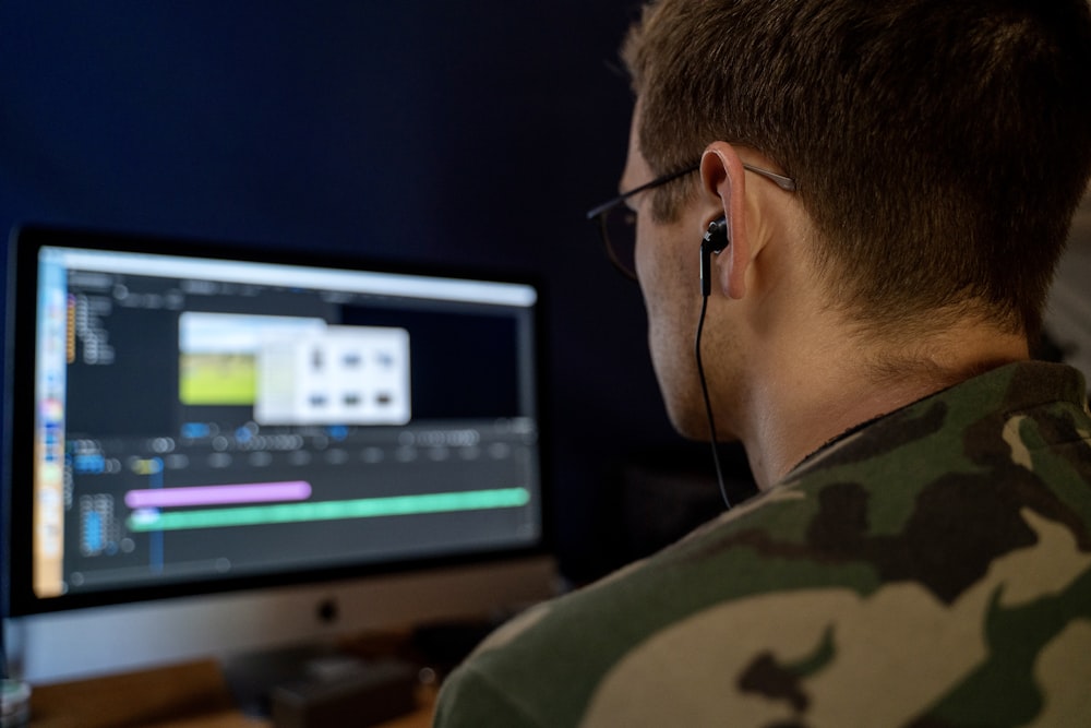 a man wearing headphones is looking at a computer screen