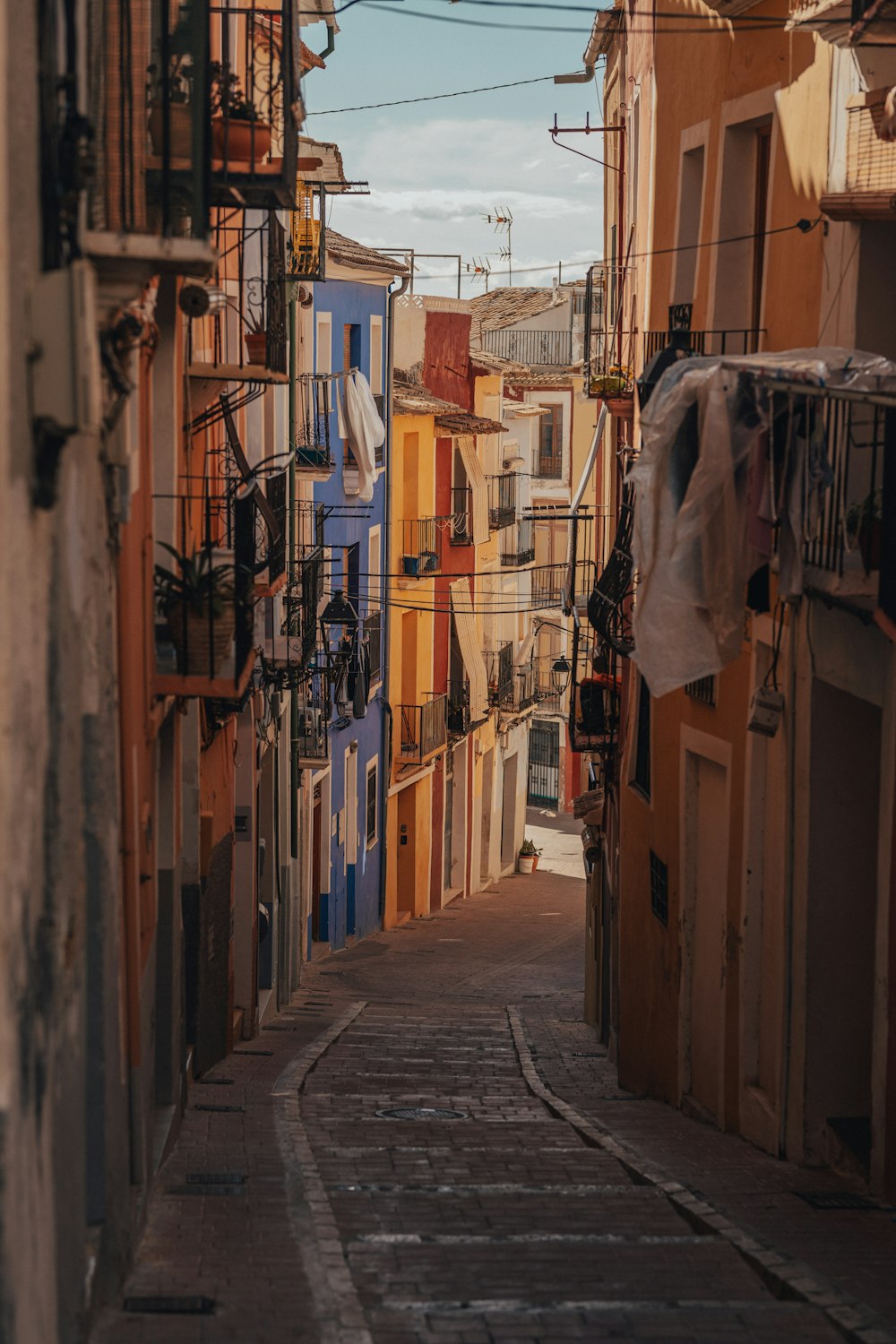 a narrow alley way with clothes hanging out to dry