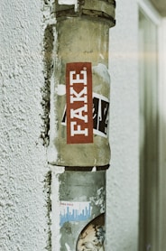 a post with a sticker on it that says fake
