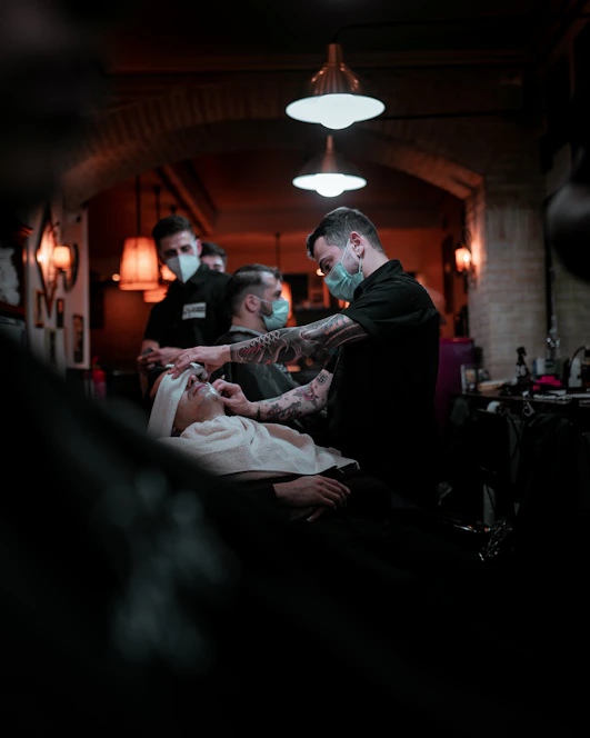 A friendly barber welcoming a customer for a haircut in a cozy salon.