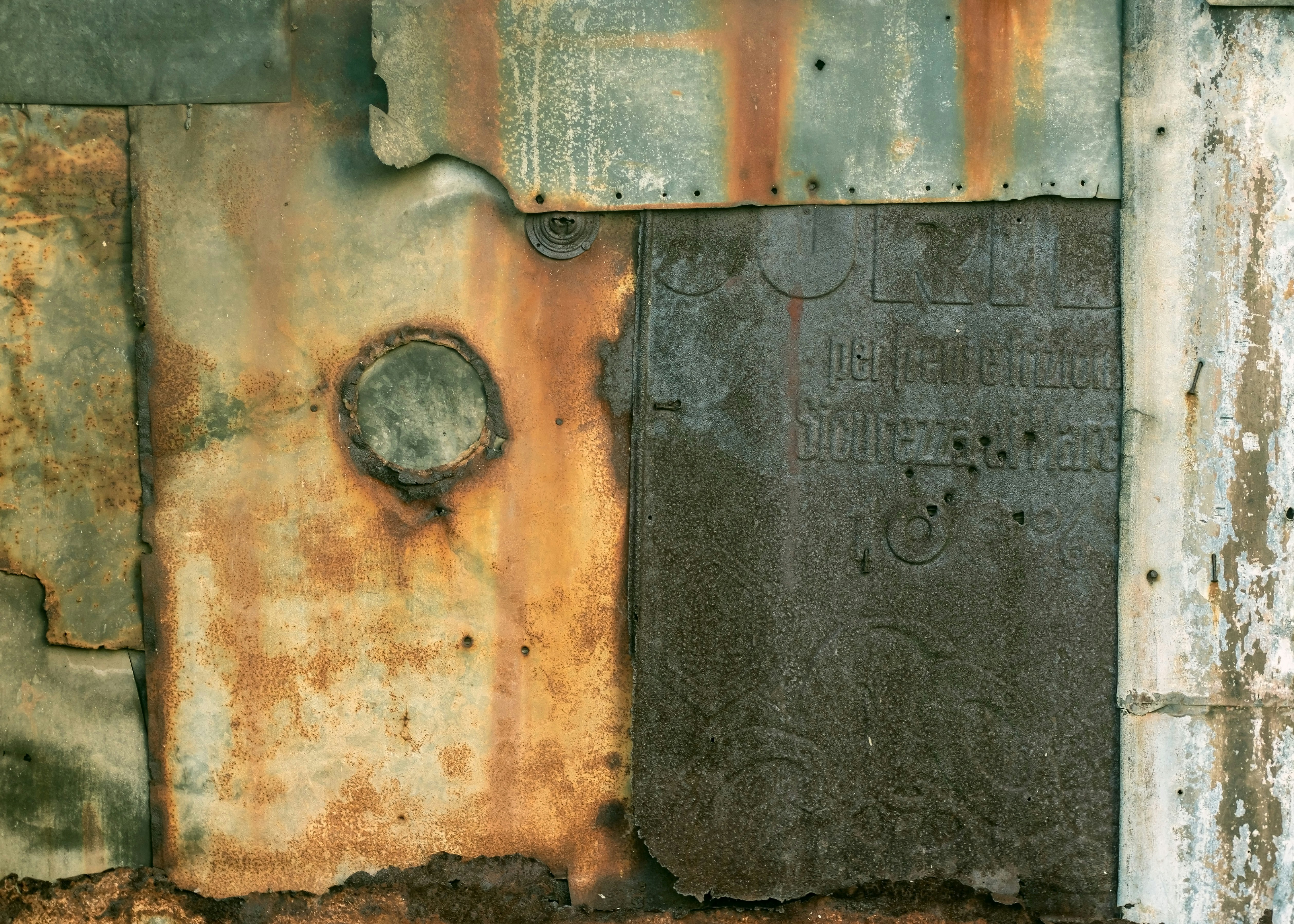 a rusted metal wall with a hole in the middle