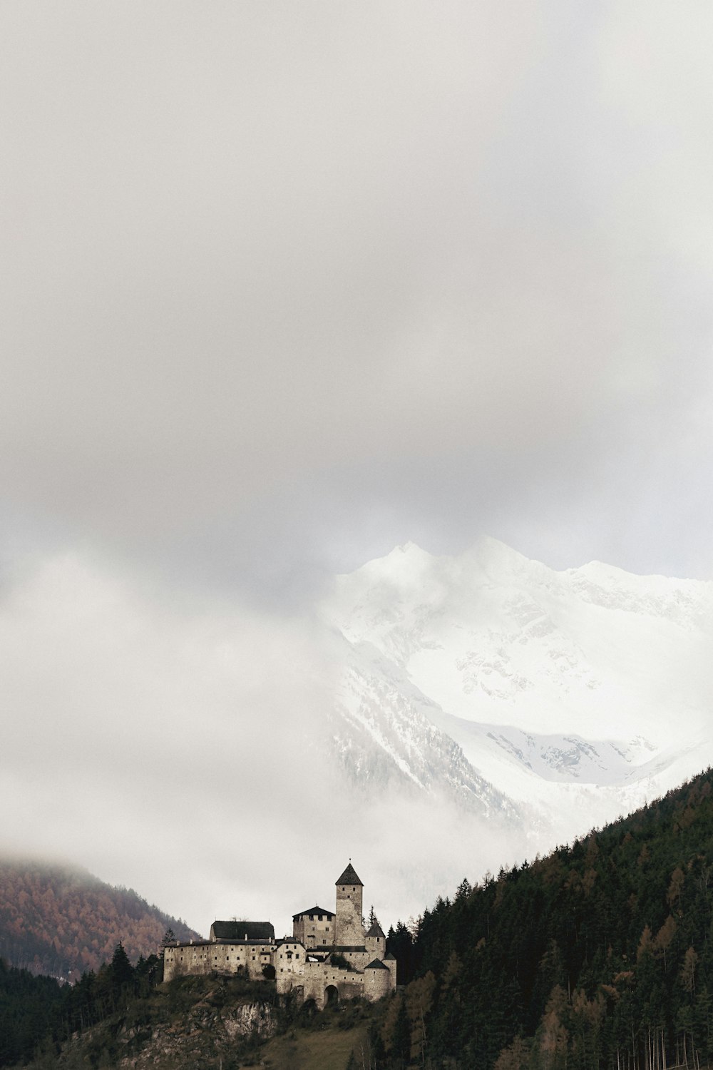 a castle on a hill with a mountain in the background