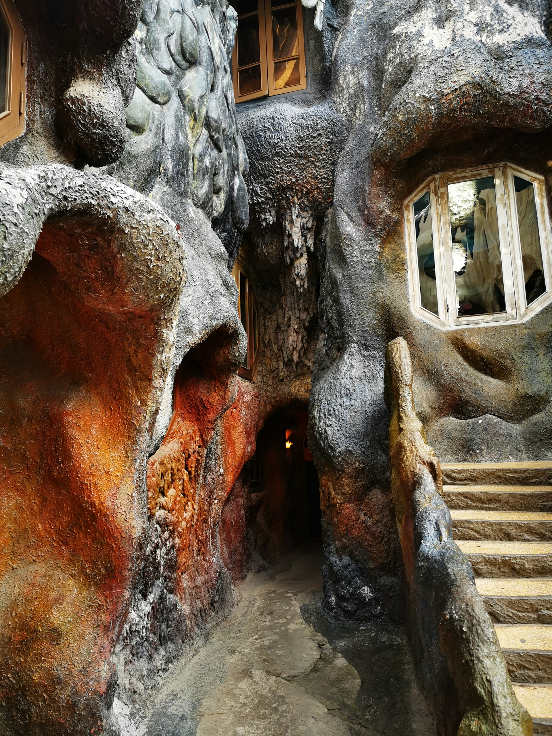A bold steel entrance framed by native stone, inviting visitors into a space where craftsmanship meets the earth’s contours.