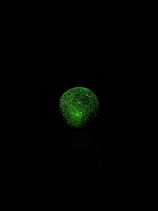A glowing, pulsing digital sphere with neon accents reacting to a user's cursor on a dark background.