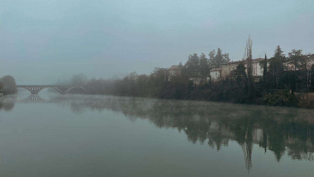 um rio nebuloso com uma ponte à distância