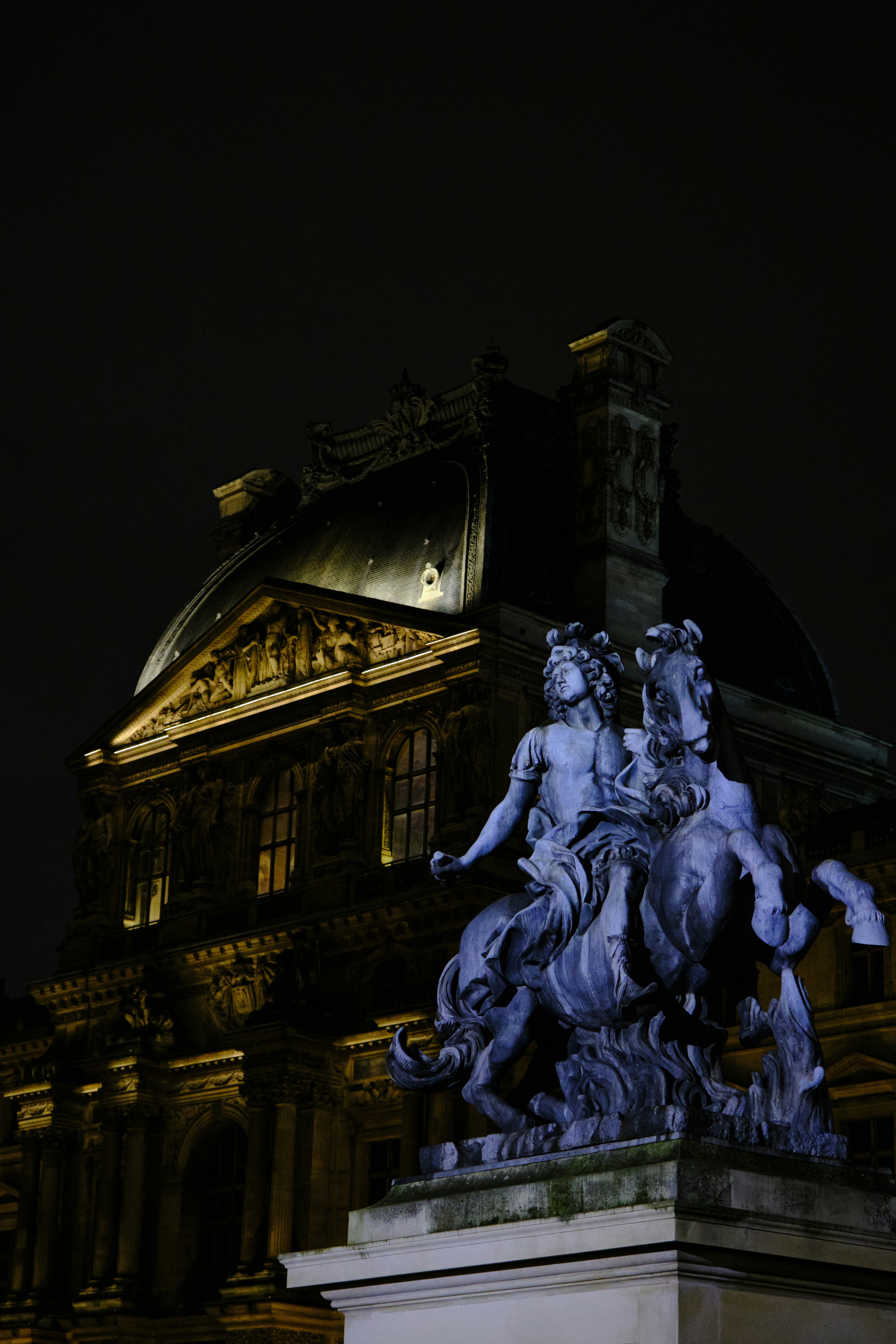 a statue of a man riding a horse in front of a building