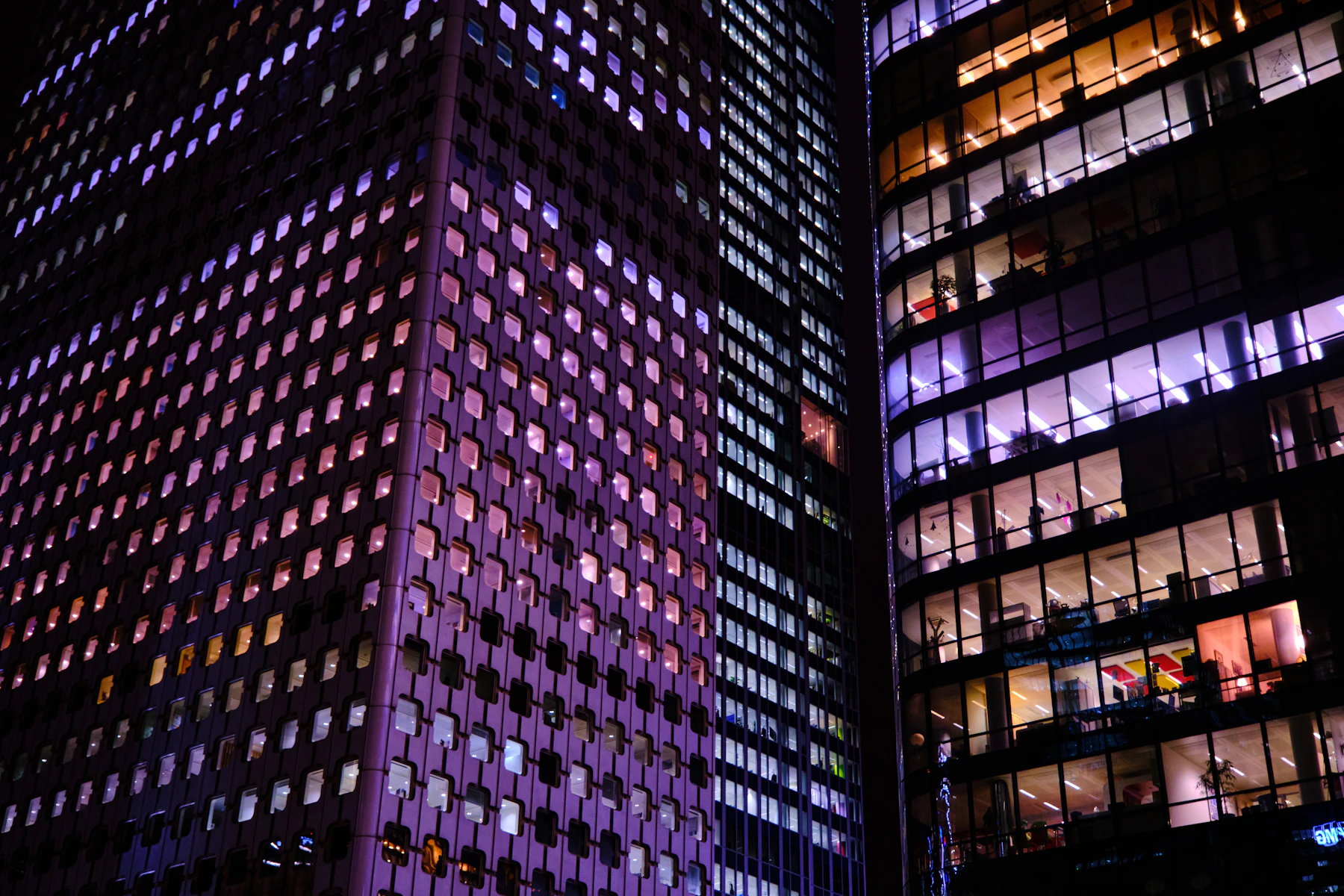 Rascacielos corporativo iluminado al anochecer
