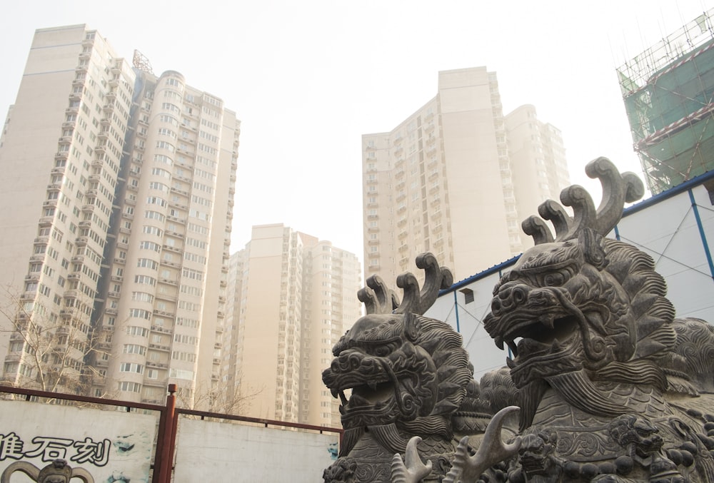 a statue in front of some tall buildings