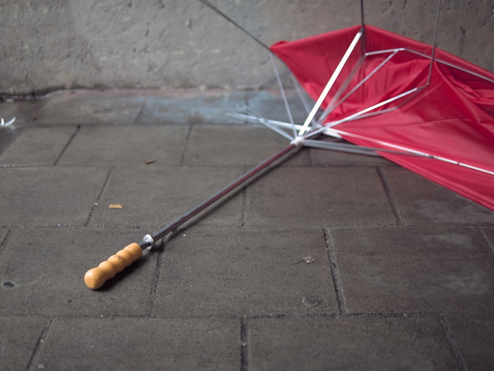 地面に逆さまに横たわる赤い傘