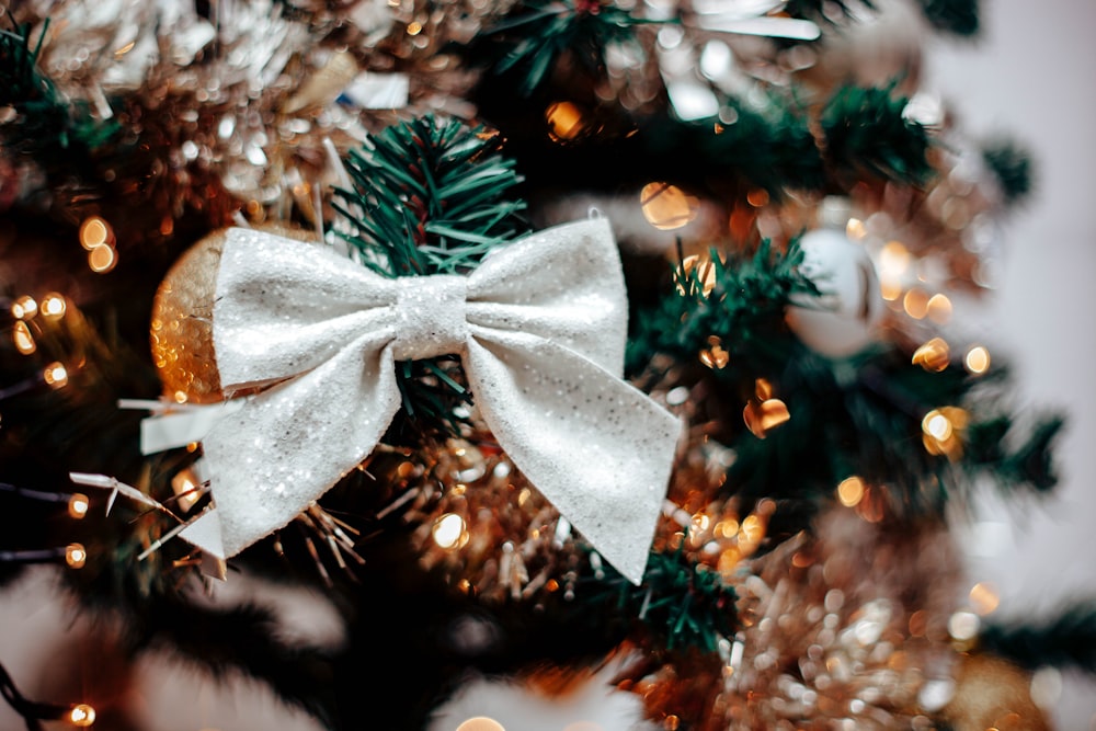 Un primer plano de un árbol de Navidad con un lazo blanco