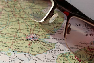a pair of glasses sitting on top of a map