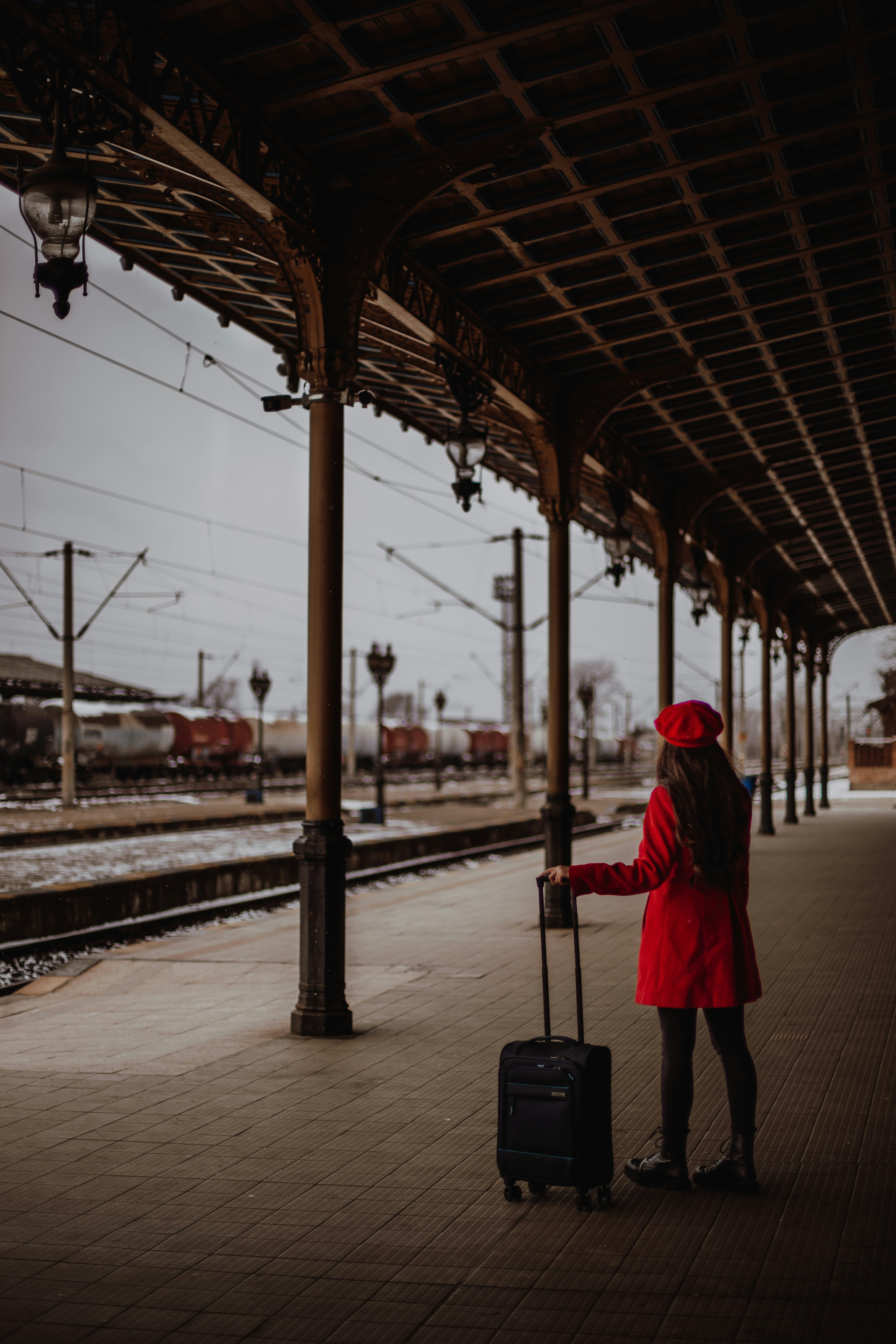 Une femme avec une valise attendant un train