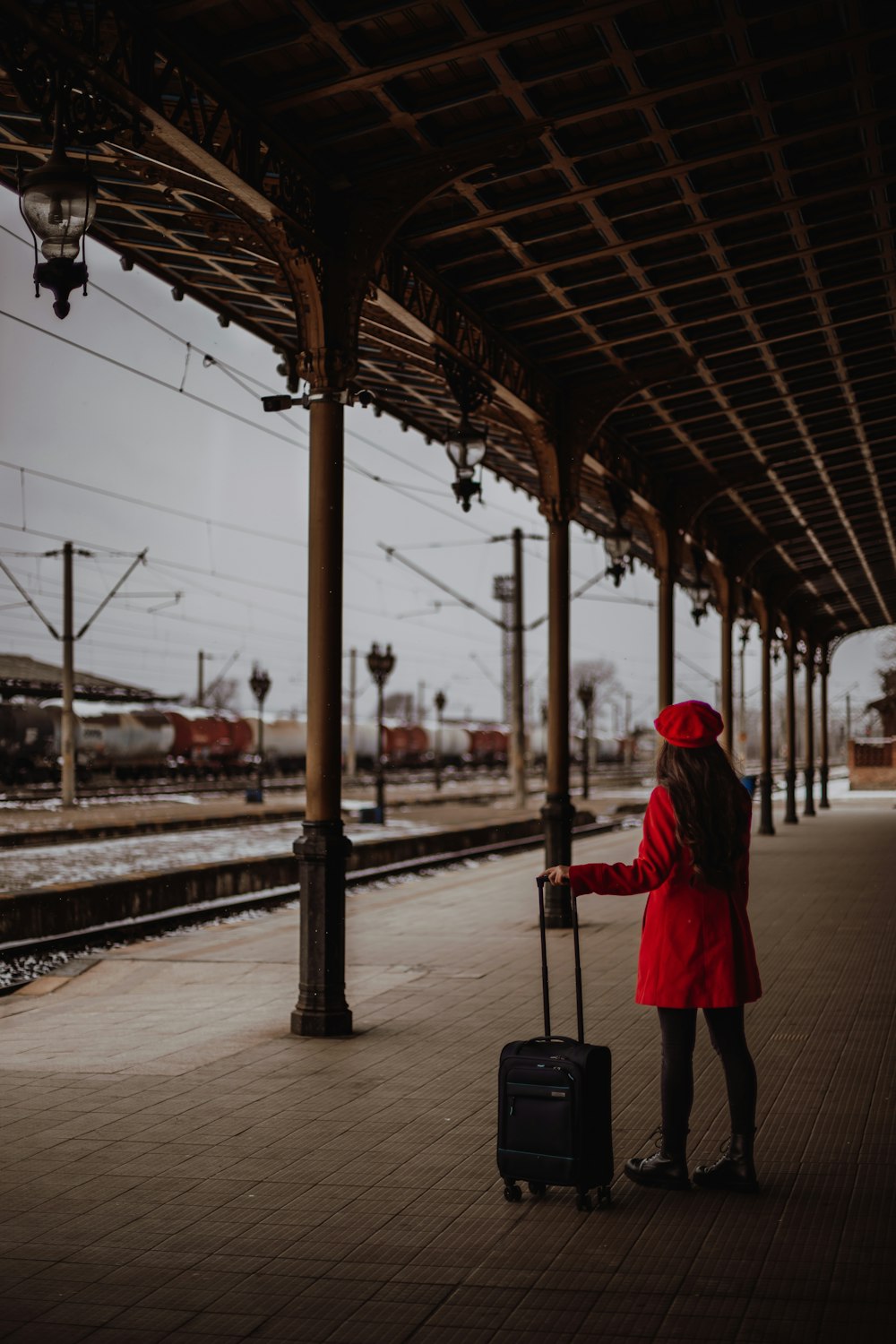 Una mujer con una maleta esperando un tren