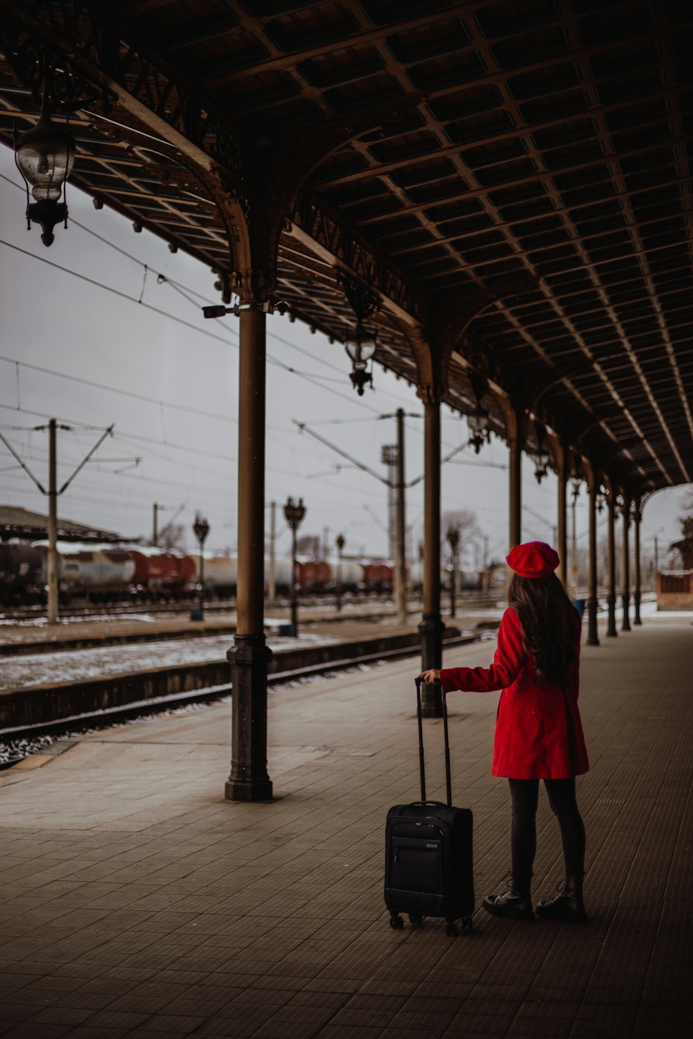a woman with a suitcase waiting for a train