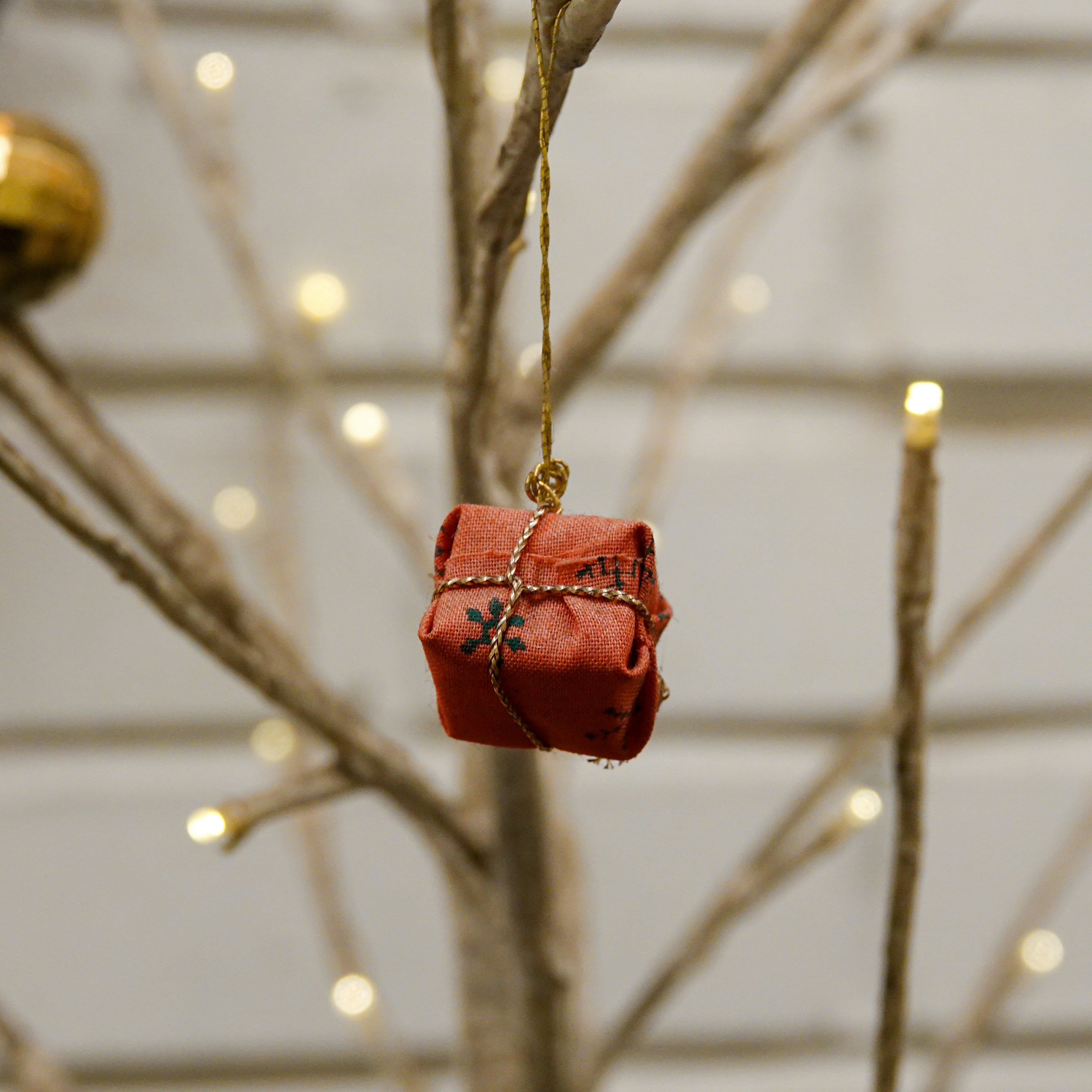 a small red present hanging from a tree