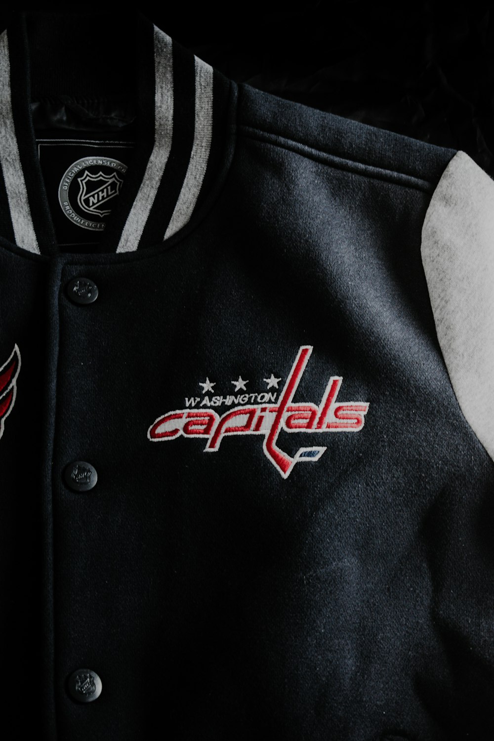 a black jacket with a red and white logo on it