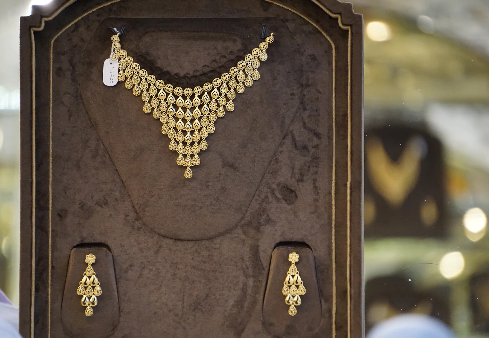 A gold necklace set in a jeweller’s display case