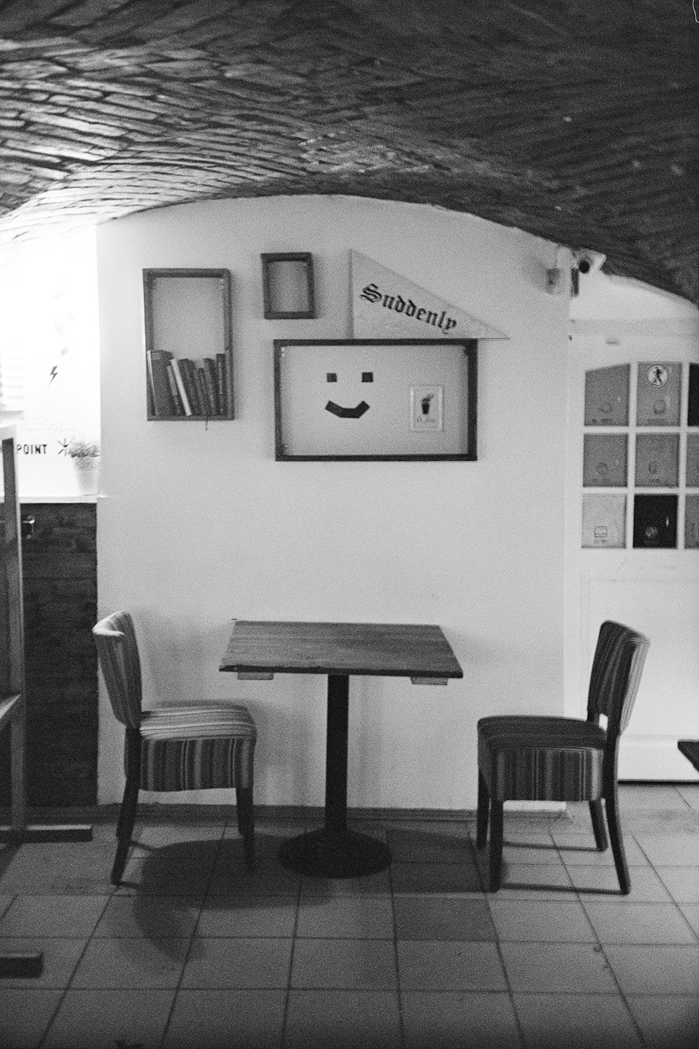 a black and white photo of a table and chairs