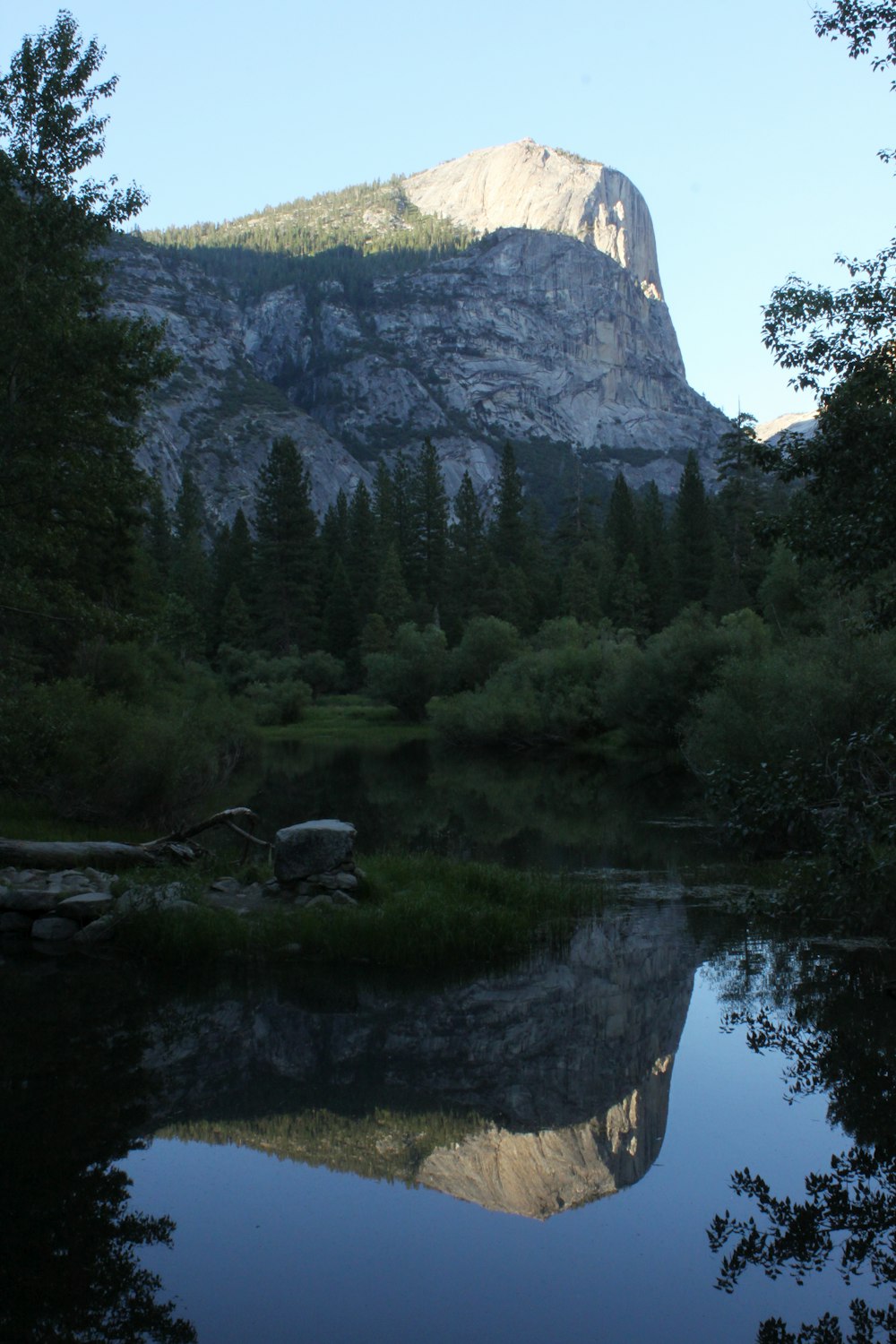 a mountain is reflected in the still water of a river