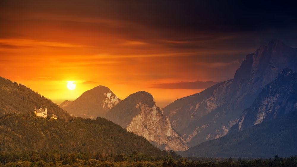 the sun is setting over a mountain range