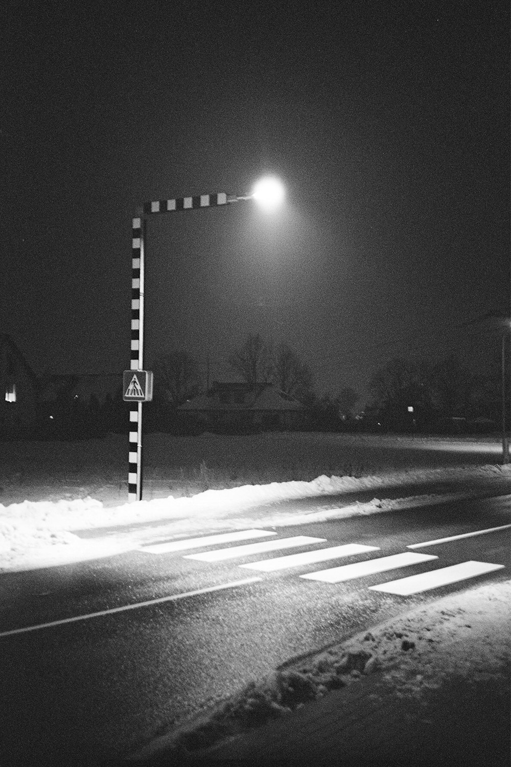 a black and white photo of a street at night