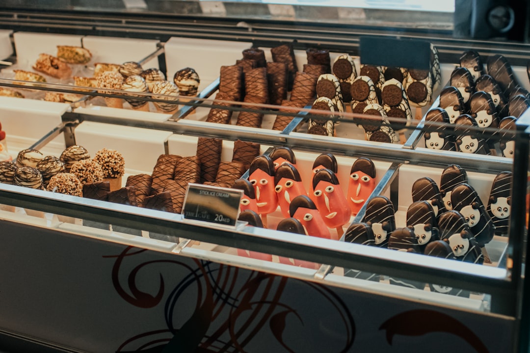 a display case filled with lots of different types of desserts, Big display showcase with lots of delicious sweets and i