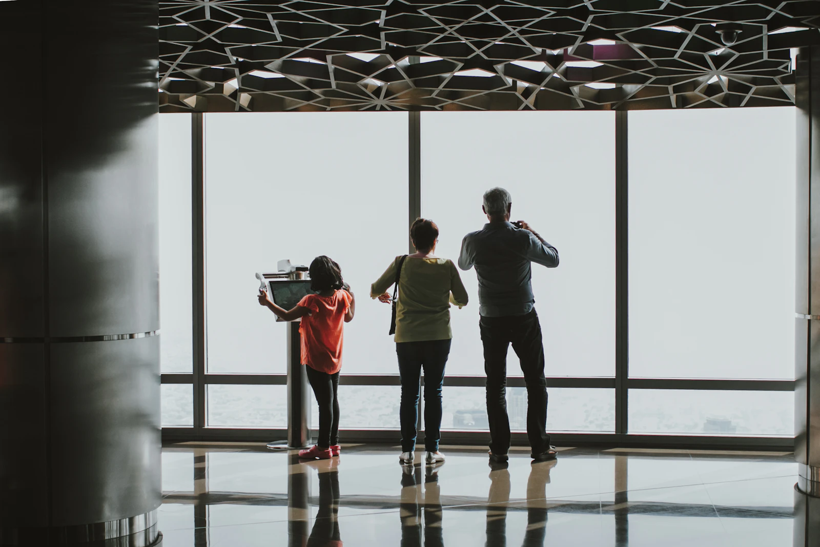 Family moving through UK travel terminal with matching luggage
